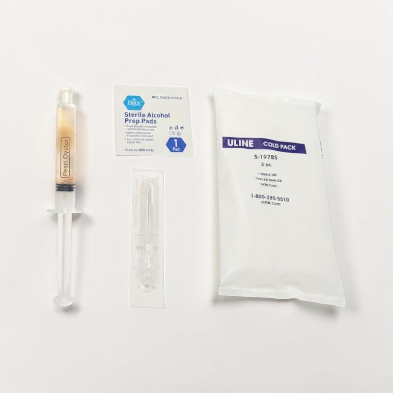 The contents of the pearl oyster liquid inoculation kit spread out including the applicator the needle the alcohol prep pad and the cold pack.